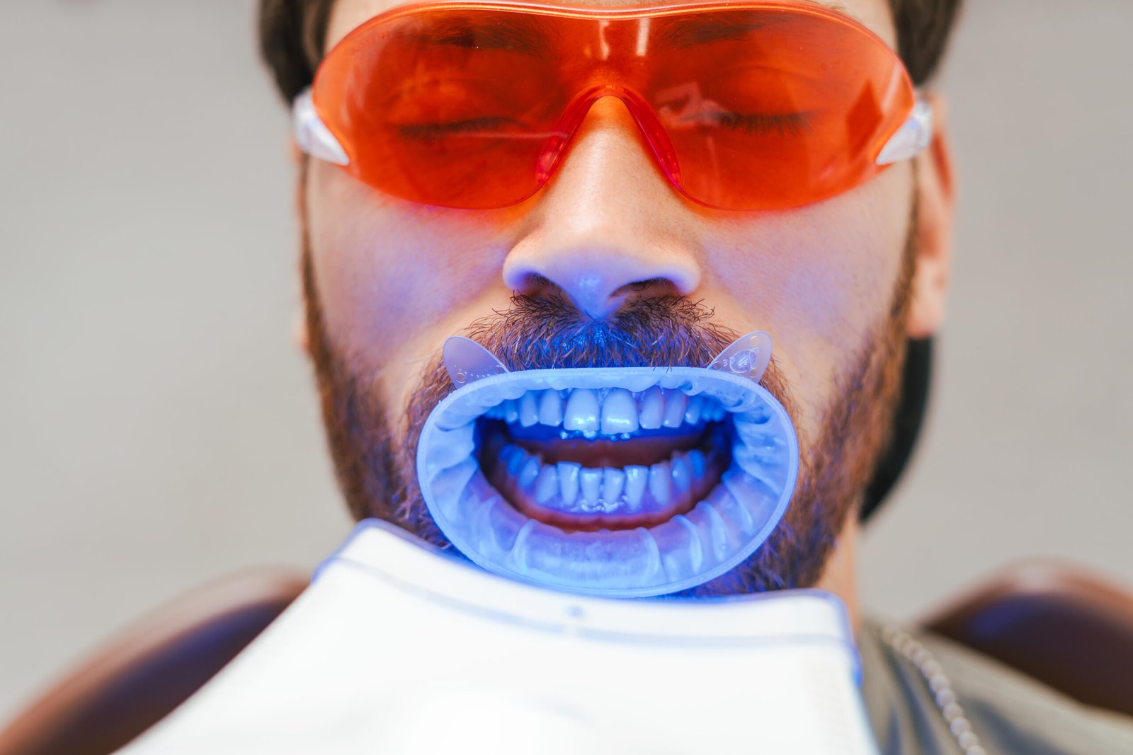 Bearded man , patient whitening teeth in modern dental clinic. Teeth treatment, health care concept