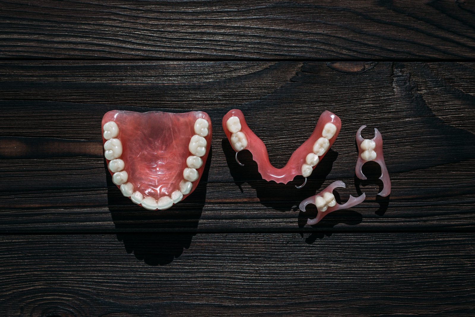 Dentures on a dark background. Close-up of dentures. Dentistry is conceptual photography. Prosthetic dentistry. False teeth. Prosthetics. Close-up of plastic dentures. Teeth on a wooden background